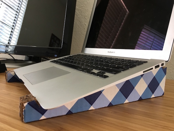 laptop opened sitting on homemade cardboard
